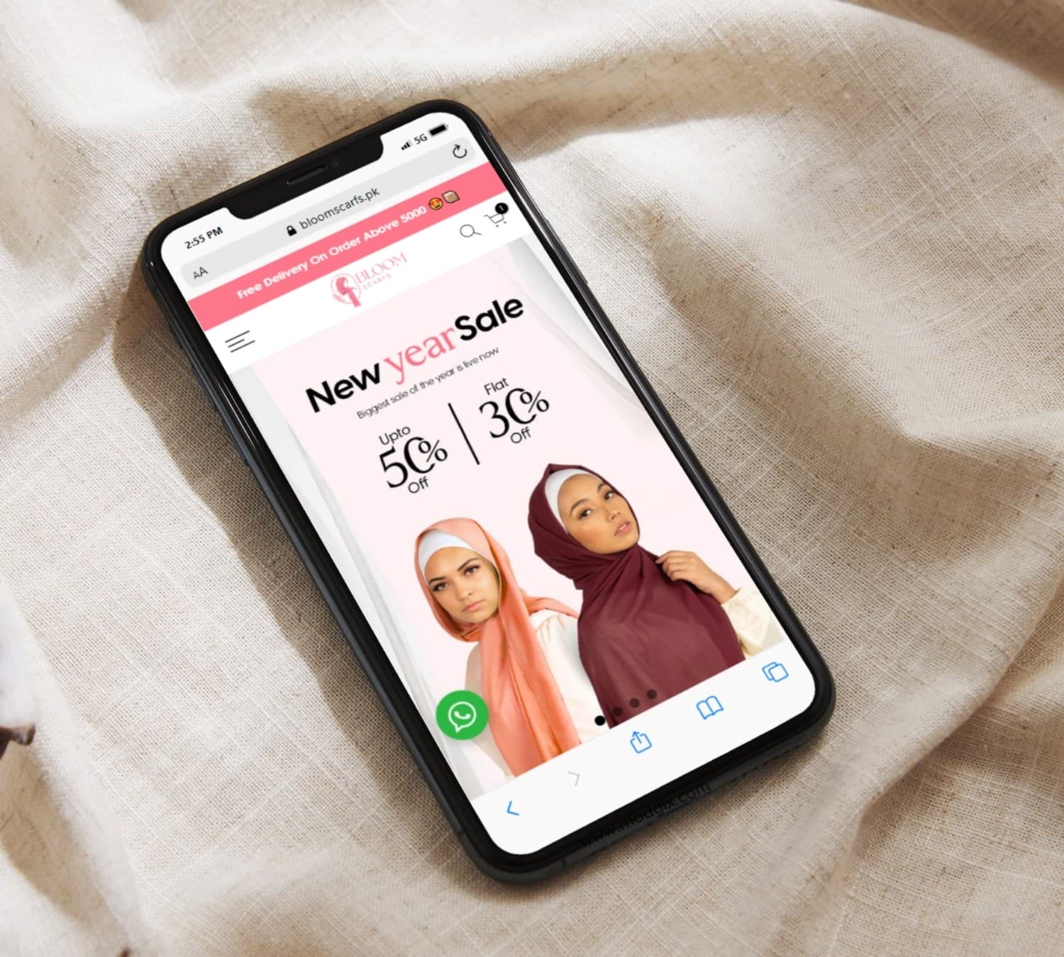 Bloomscarfs sale page on a phone resting on fabric