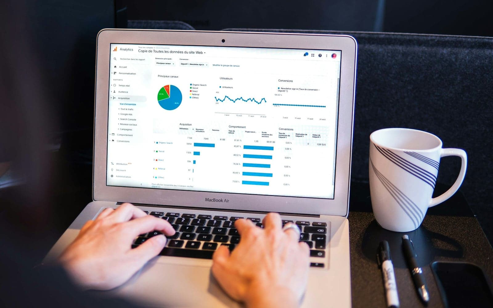 Hands on a laptop showing a campaign analytics dashboard
