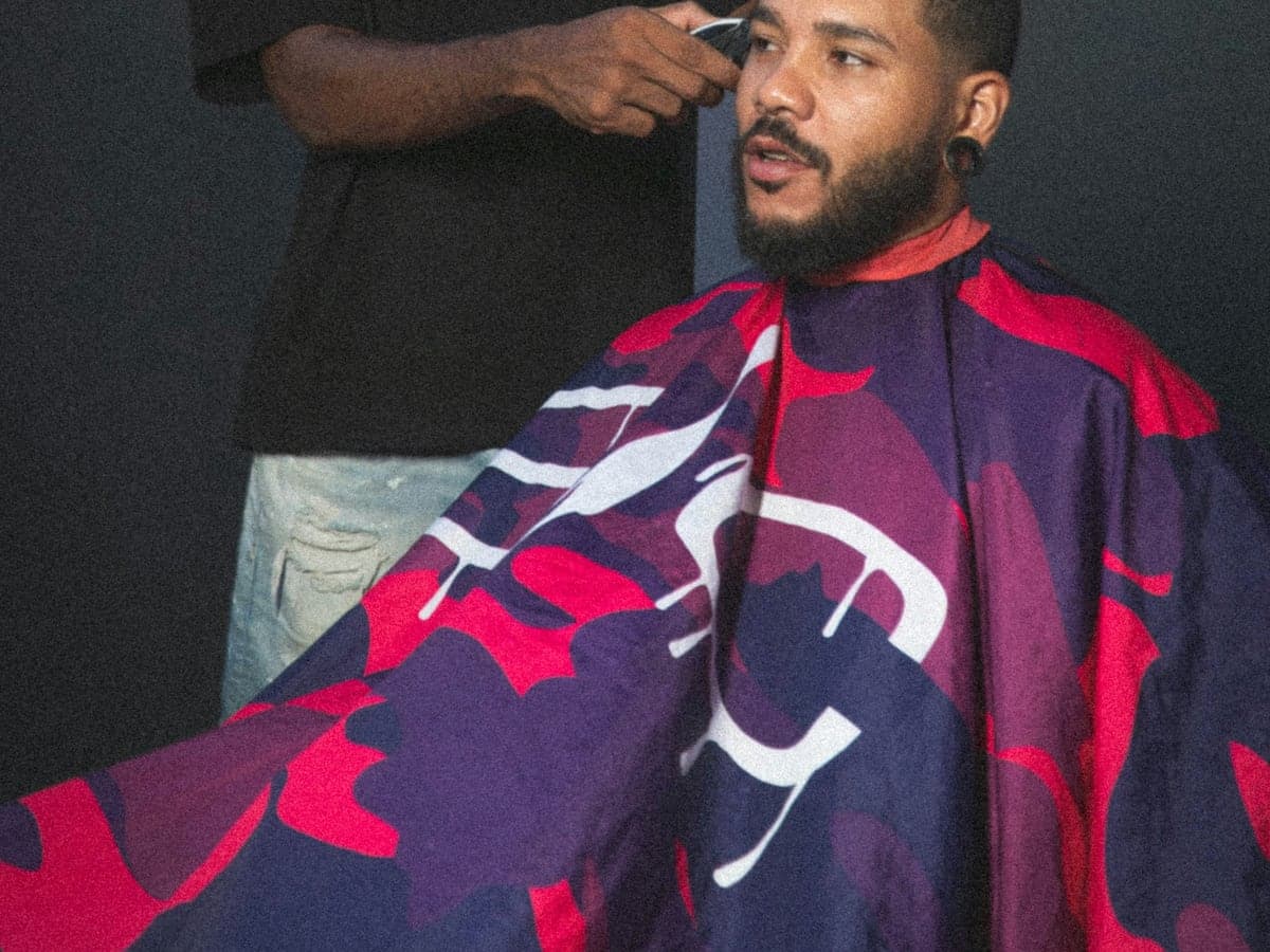 A barber finishing a client's haircut
