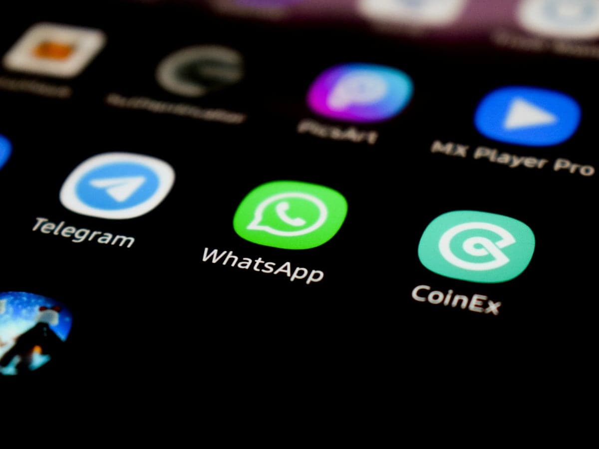 A phone home screen with the WhatsApp icon in focus