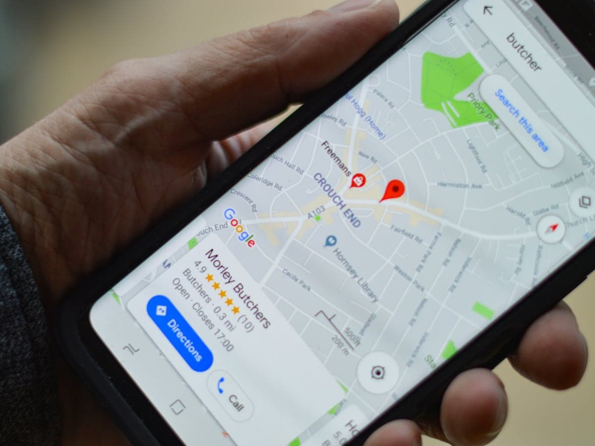 A phone showing a map search, with a local shop's listing and a directions button