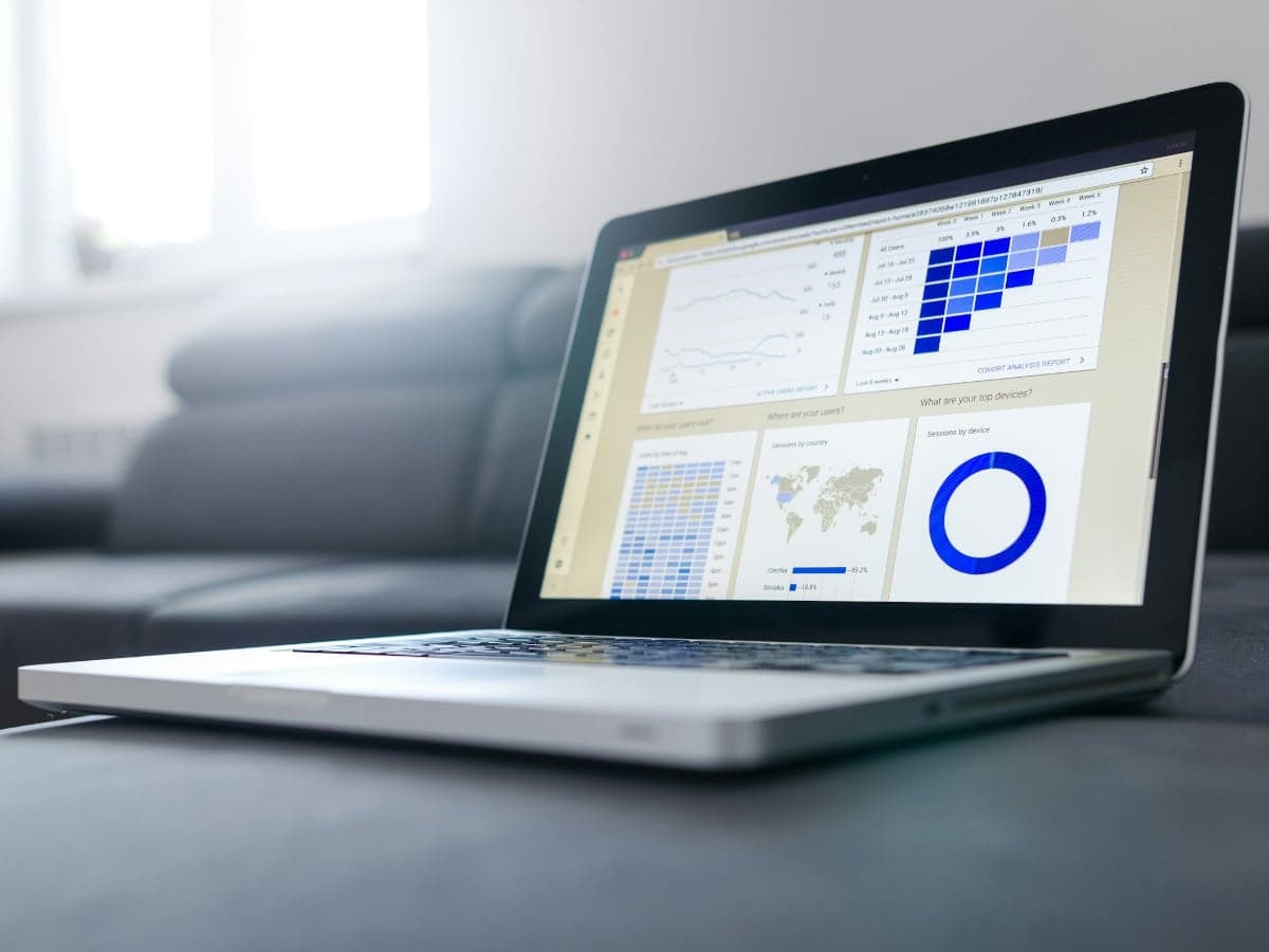 A laptop on a desk showing traffic and ranking charts