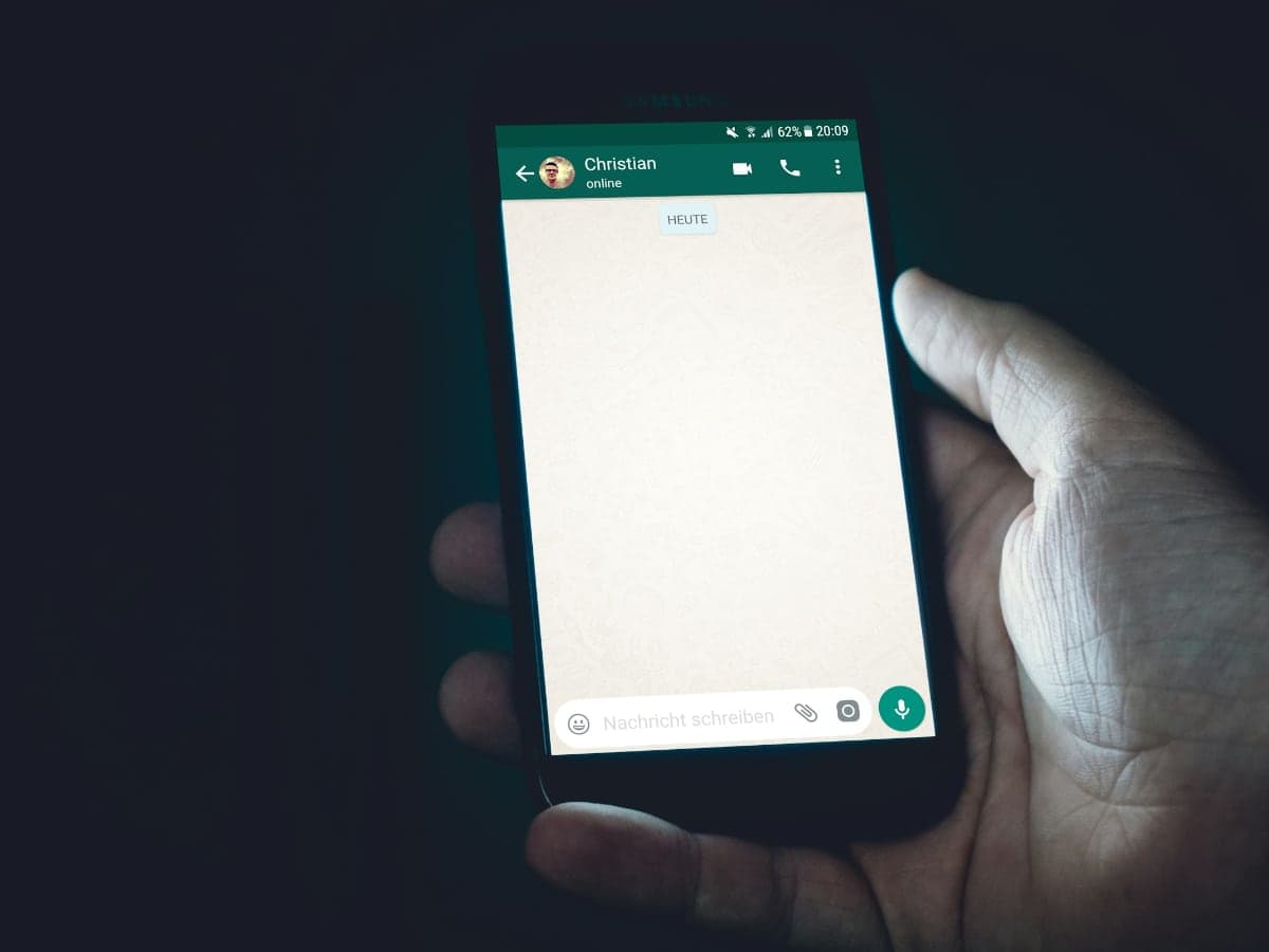 A hand holding a phone with a conversation open
